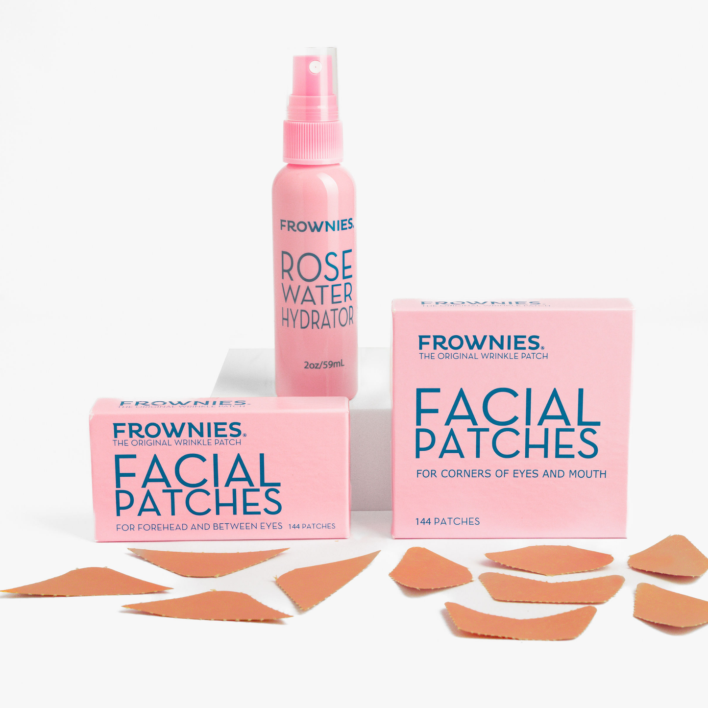 Frownies Startkit med Rose Water Hydrator, Facial Patches och ansiktsplåster utspridda mot vit bakgrund.