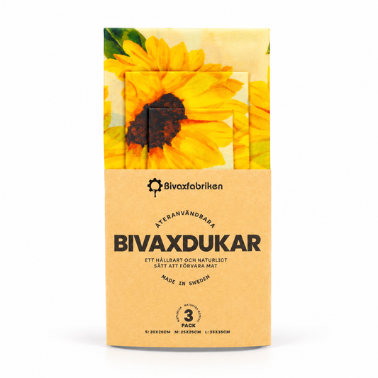Bivaxfabriken bivaxdukar i tre storlekar med gult solrosmönster och pappersförpackning, mot vit bakgrund.