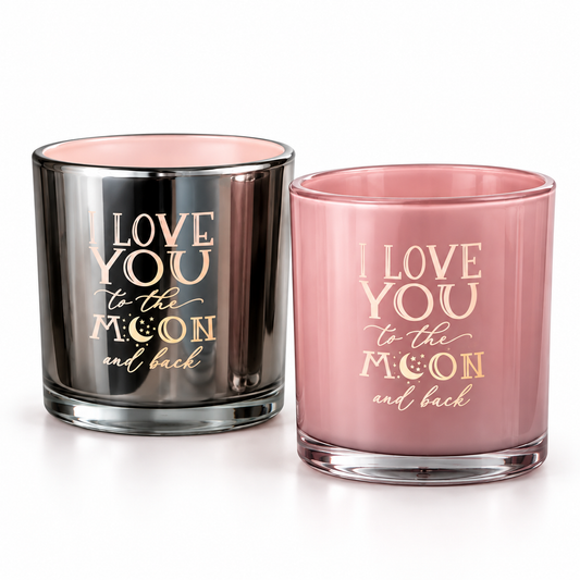 Två doftljus från Majas Cottage med texten Love You to the Moon and Back, ett i rosa glas och ett i mörkt spegelglas med roséguldfärgad text, mot vit bakgrund.